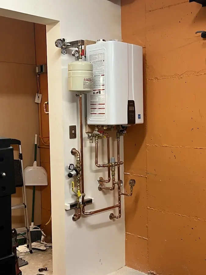 Plumbing technician inspecting water heater connections in Asbury Park